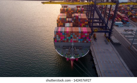 crane loading cargo container to container ship in the international terminal yard port  concept freight shipping by ship at sunrise .