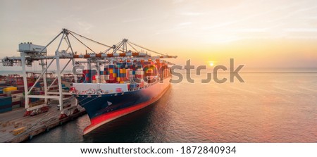 Crane loading cargo container to cargo ship stand by in the international terminal logistic container depot sea port  concept freight shipping by ship at sunset