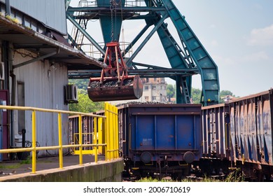 Crane Loading Train Wagon With Coal From Barge At The River Port.