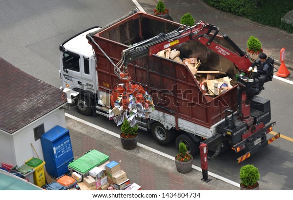 The crane is loading the truck with\
recycled waste in Asia. (Daegu, Korea. Jun. 6,\
2019)