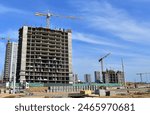 Crane on Construction. Buildings under construction. Tower cranes in action during formworks of house. Multi Storey Residential Buildings construction. on Construction site, Housing renovation.