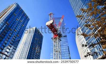 Crane on the construction site in a site surrounded by the high buildings.