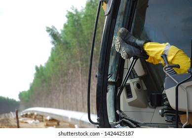 Crane Operator Resting At Lunch Time On Pipeline Construction Site.