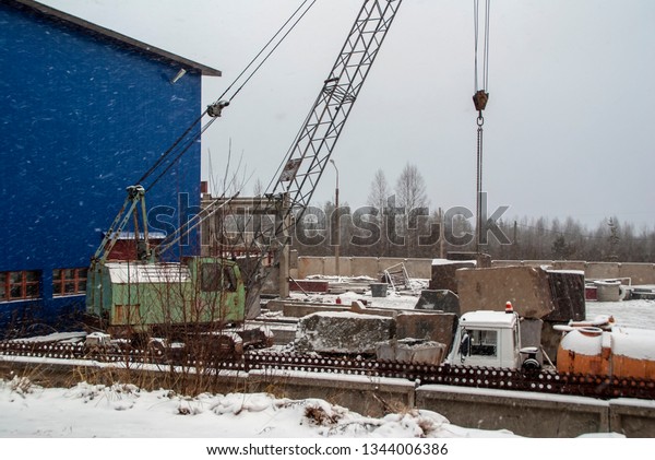 Crane and trucks\
on granite processing\
plant