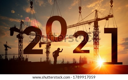 Cranes building construction 2021year sign,Silhouette staff works as a team to prepare to welcome the new year 2021