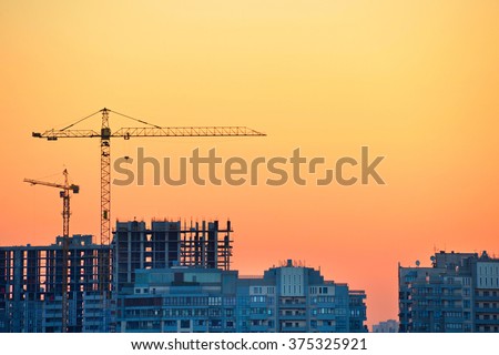 Cranes at construction site in the colorful sunset
