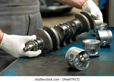 The crankshaft, a set of pistons close-up on the desktop of an auto mechanic. Spare parts of the car suspension. Control of the technical condition of new products. Repair and maintenance.