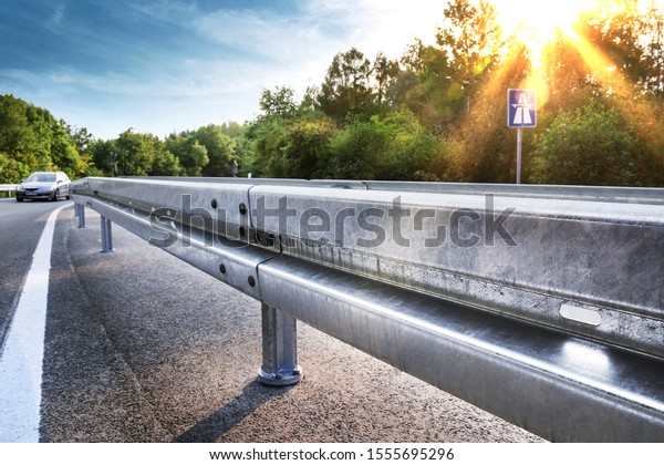 Crash barrier in\
back light on german\
highway