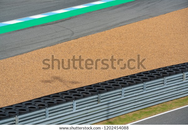 crash barrier with\
pebbles, Asphalt road circuit and safety fence on race track. Race\
Track Construction kit.