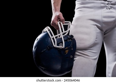 Crash Helmet.  Cropped Image Of American Football Player Holding Football Helmet While Standing Against Black Background 