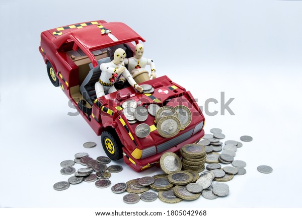 Crash Test Dummies in a car hitting UK coines
on a white background
