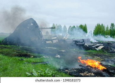 The crash of a transport plane outside the city in the countryside. A charred plane after a crash.