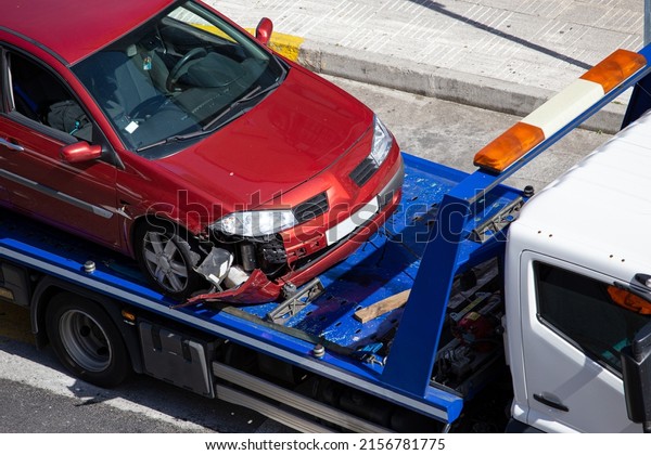 Crashed car loaded on a tow truck. Damage\
vehicle after crash accident on city\
street