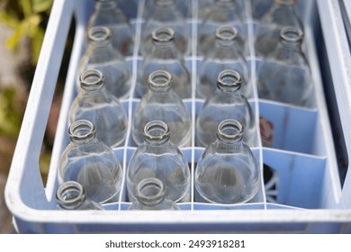 A crate full of empty bottles. The crate is blue and white