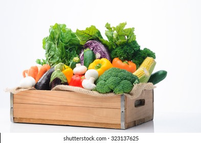 Crate of raw fresh vegetables from the farmers market, assortment of corn, peppers, broccoli, mushrooms, beets, cabbage, parsley, tomatoes, isolated on light background - Powered by Shutterstock