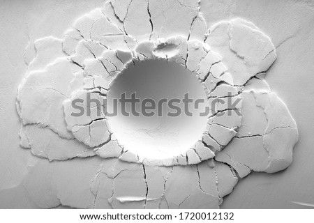 A crater on white powder background. Round crater with cracks.   