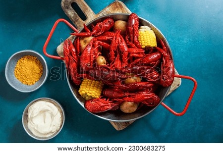Crawfish boiled Louisiana,with corn on the cob, potatoes. Crawfish boiled in Cajun seasonings and herbs.with beer, New Orleans, Cajun or Creole cuisine, blue background                            