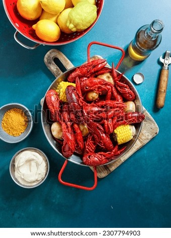 Crawfish boiled Louisiana,with corn on the cob, potatoes. Crawfish boiled in Cajun seasonings and herbs.with beer, New Orleans, Cajun or Creole cuisine, blue background                            
