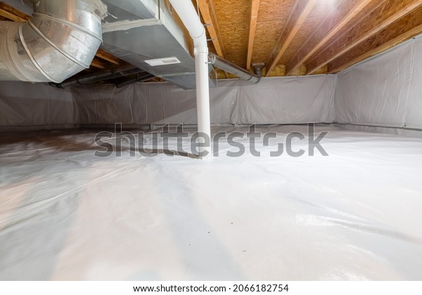 Crawl space fully\
encapsulated with thermoregulatory blankets and dimple board. Radon\
mitigation system pipes visible. Basement location for energy\
saving home improvement\
concept.