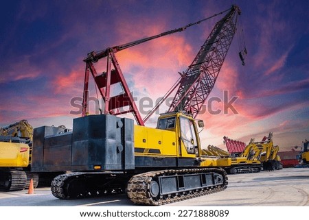 Crawler crane against sunset sky background