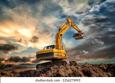 Crawler excavator during earthmoving works on construction site at sunset