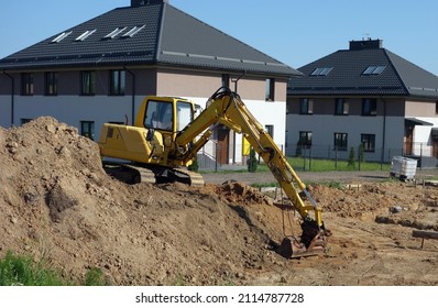 Crawler excavator on the construction site - work on the construction of the house has started - Shutterstock ID 2114787728