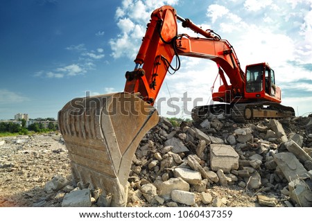 Crawler excavator on demolition site. Front view of a big crawler excavator working on demolition site.