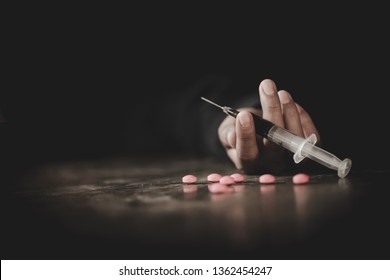 A crazed drug addict reaches for another dose of the drug in the syringe. Guy addicted, The concept of anti drugs. male drug addict, drug syringe.
