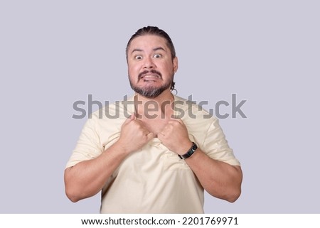 A crazed man pretends to rip his shirt off. An animated guy acting funny. Isolated on a gray background.