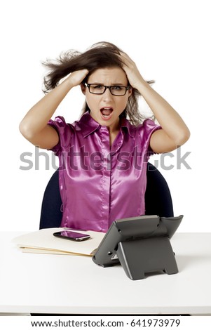 Crazy, angry and frustrated business woman working at her desk and talking on phone
