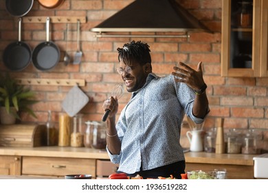 Crazy Cook. Inspired African American Male Relax Having Fun Sing Favorite Song Dance By Music At Kitchen Counter Make Microphone From Tools. Positive Funny Black Hipster Guy Cooking Food With Feeling