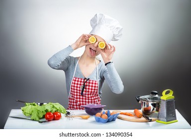 Crazy cooking woman with lemon eyes on grey background