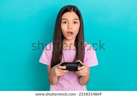 Crazy emotion of young funny girl hold joystick surprised playing free time fortnite lose tournament isolated on blue color background