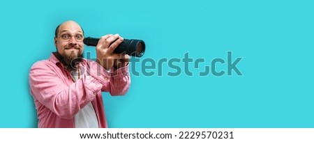 Crazy emotions. Young funny hipster tourist looking through a spyglass and considering the sights isolated on studio background. Looking for discounts, sale, seasonal sales. Colorful summer concept.