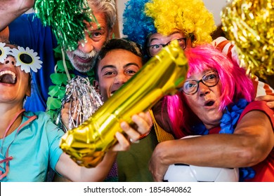 Crazy Family Mixed Ages Celebrate And Enjoy The Football Match Together With Coloured Clothes Of The Team - Group Of People Enjoy The Sport Watch Activity At Home And Have Fun Championship Tournament