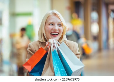 Crazy Fashion Girl Doing Shopping In Mall Center - Happy Blond Woman Having Fun Buying New Clothes - Consumerism, People And Youth Lifestyle Concept. 