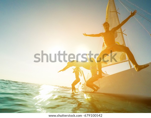 狂った友達がボートから海に飛び降りる 楽しい海に飛び込む若い幸せな人々 旅行 熱帯 夏 コンセプト の写真素材 今すぐ編集