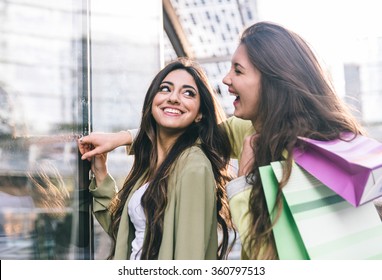 Crazy girls making shopping in the city center. Best friends spending time and having fun in Milan city center