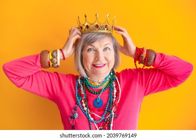 Crazy grandmother funky action smile. Happy smiling natural senior woman with a crown on her head on yellow background. Pensioner and mature people, new seniors, about seniority. - Powered by Shutterstock