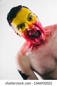 Crazy Guy Posing With A Painted Face. A Bizarre Portrait Of A Man With A Painted Body. Concept: Sports Fan