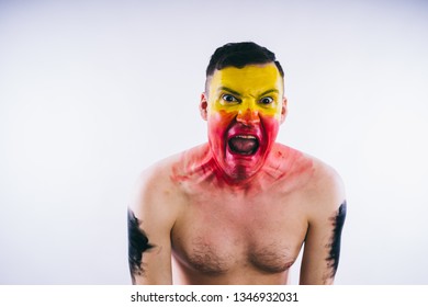 Crazy Guy Posing With A Painted Face. A Bizarre Portrait Of A Man With A Painted Body. Concept: Sports Fan