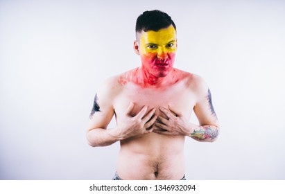 Crazy Guy Posing With A Painted Face. A Bizarre Portrait Of A Man With A Painted Body. Concept: Sports Fan