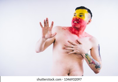 Crazy Guy Posing With A Painted Face. A Bizarre Portrait Of A Man With A Painted Body. Concept: Sports Fan