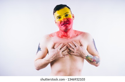 Crazy Guy Posing With A Painted Face. A Bizarre Portrait Of A Man With A Painted Body. Concept: Sports Fan