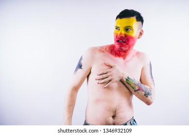 Crazy Guy Posing With A Painted Face. A Bizarre Portrait Of A Man With A Painted Body. Concept: Sports Fan