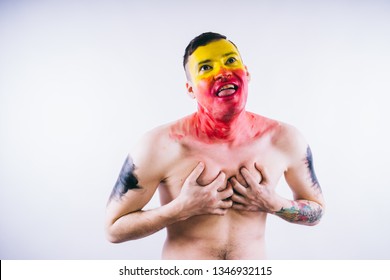 Crazy Guy Posing With A Painted Face. A Bizarre Portrait Of A Man With A Painted Body. Concept: Sports Fan