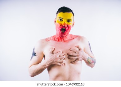 Crazy Guy Posing With A Painted Face. A Bizarre Portrait Of A Man With A Painted Body. Concept: Sports Fan