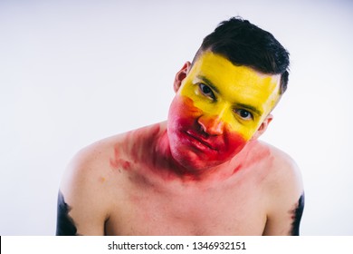 Crazy Guy Posing With A Painted Face. A Bizarre Portrait Of A Man With A Painted Body. Concept: Sports Fan