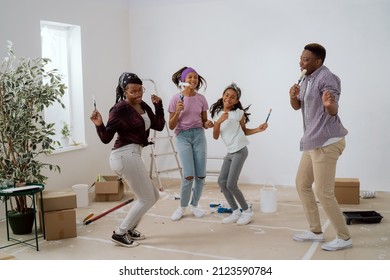 Crazy Happy Family Painting The Walls With White Paint With Brushes, They Dance In The Middle Of The Room, Singing, Parents Play With Children, The House Prepared For Renovation