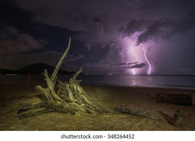 Crazy Lightning In The Sea And Dead Tree Root On Beach